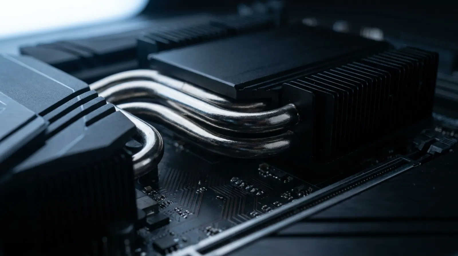 Vernickelte Heatpipes über schwarzen Kühlrippen im kalten Licht